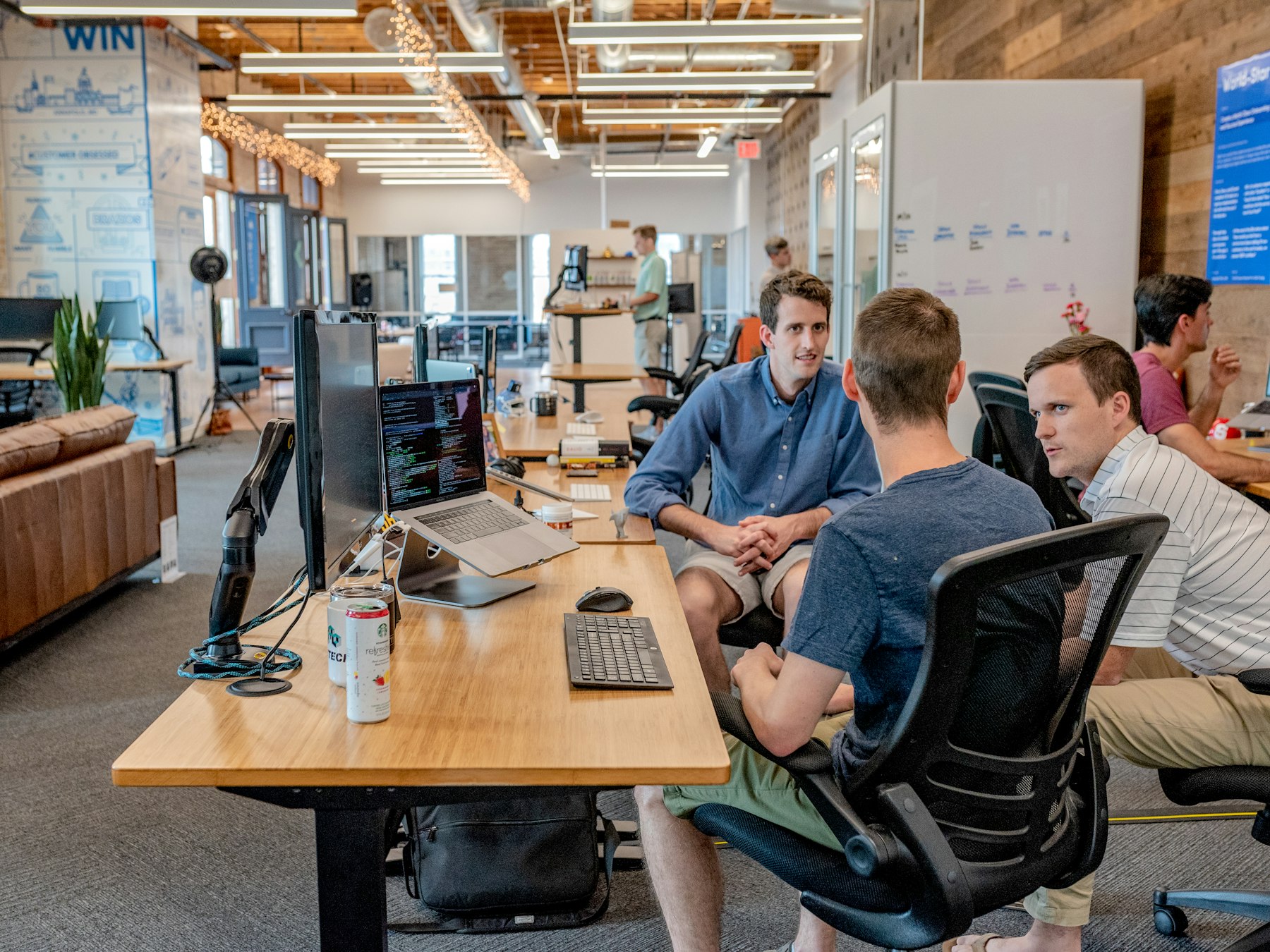 People collaborating around laptops in an open workspace.