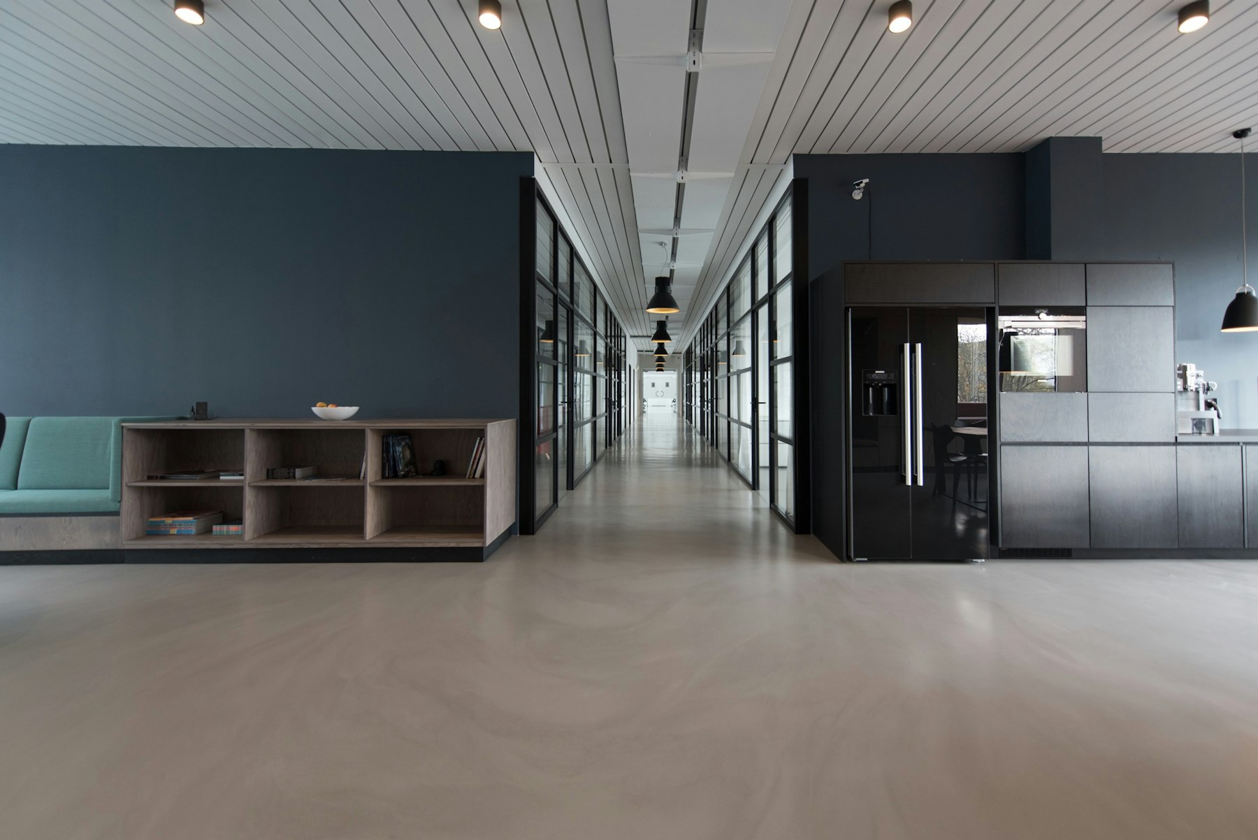 A bright office with glass rooms and calm daylight.