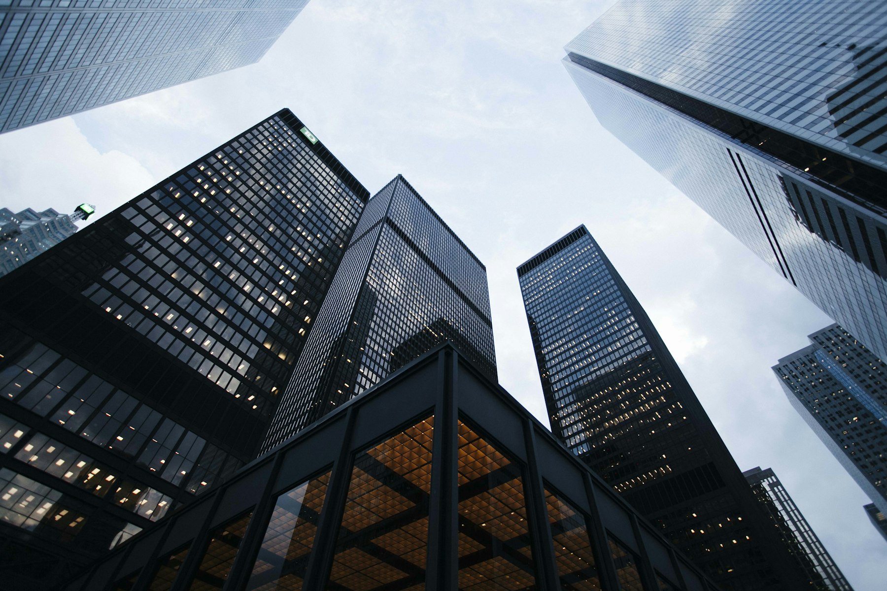Looking up at glass towers against an overcast sky.